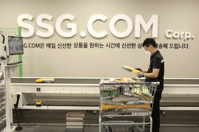 이마트 이천점 PP센터에서 작업자가 자동화 소터에 상품을 투입하는 모습.(사진=SSG닷컴 제공)