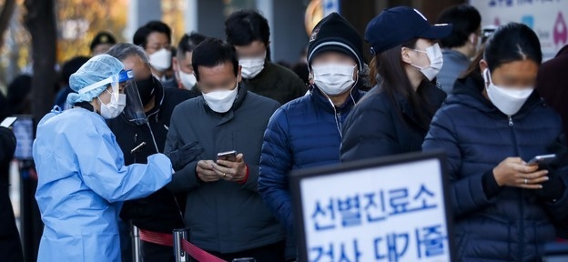 지난 12일 오전 서울 송파구보건소에 설치된 코로나19 선별진료소를 찾은 시민들이 검사를 받기 위해 줄 서 있다. (사진 제공=뉴시스)