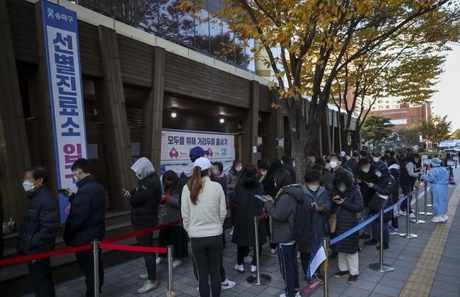 지난 12일 오전 서울 송파구보건소에 설치된 코로나19 선별진료소를 찾은 시민들이 검사를 받기 위해 줄 서 있다.
