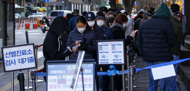 지난 12일 오전 서울 송파구보건소에 설치된 코로나19 선별진료소를 찾은 시민들이 검사를 받기 위해 줄 서 있다. (사진=뉴시스 제공)