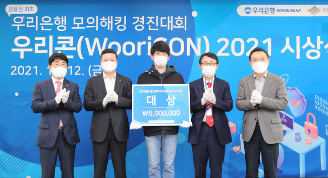 우리은행은 지난 12일 서울시 중구 회현동에 위치한 우리은행 본점에서 ‘모의해킹 경진대회 WooriCON’ 시상식을 개최했다. 권광석 우리은행장(왼쪽에서 두번째), 김영기 금융보안원장(왼쪽에서 첫번째), 고정현 우리은행 정보보호그룹장(왼쪽에서 다섯번째), 박춘식 아주대학교 교수(왼쪽에서 네번째)가 대상 수상자와 기념 촬영을 하고 있다.