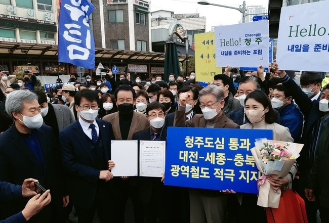  21일 충북 청주 육거리종합시장을 찾은 더불어민주당 이재명 후보가 청주도심 통과 노선 추진을 약속한다고 서명한 뒤 기념 촬영을 하고 있다. (사진=청주도심통과 광역철도 쟁취 범비대위 제공)