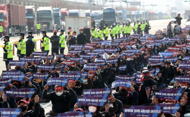 민주노총 공공운수노조 화물연대본부가 5년 만에 총파업에 돌입한 25일 오전 부산 강서구 부산신항 삼거리에서 화물연대 부산지부 조합원 1000여 명이 파업 출정식을 갖고 있다.