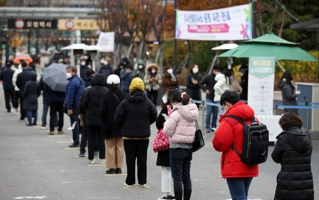 코로나19 신규 확진자가 3,901명으로 집계된 26일 오후 서울 서초구 고속터미널역 임시선별검사소에서 시민들이 검사를 받기 위해 줄을 서고 있다.