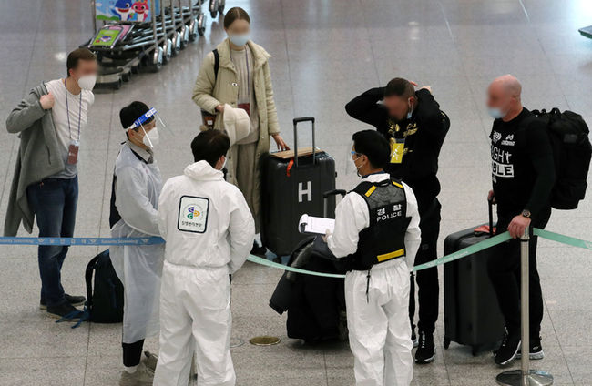 지난 2일 인천국제공항 제1여객터미널에서 해외 입국자들이 임시 생활시설로 가기 위해 질병관리본부 직원의 안내를 받고 있다. (사진=뉴시스 제공)