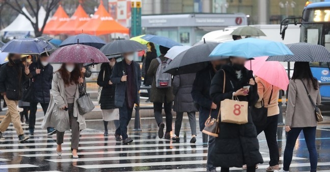 전국에 겨울비가 내린 지난달 30일 오전 세종대로 사거리에서 우산을 든 시민들이 출근길 발걸음을 옮기고 있다.