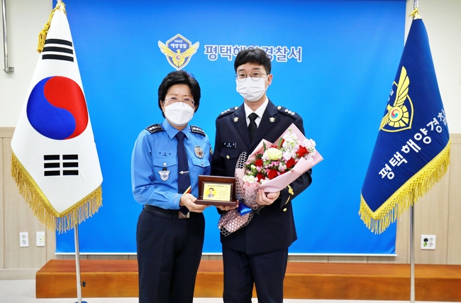 박경순 평택해양경찰서장(왼쪽)이 12월의 자랑스러운 평택해경인으로 선정된 권형준 경장에게 공로패를 수여한 뒤 기념사진을 찍고 있다.