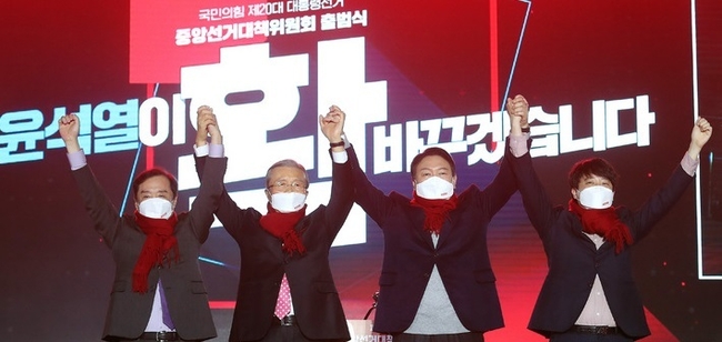  윤석열 국민의힘 대선 후보가 6일 서울 송파구 올림픽공원 체조경기장에서 열린 제20대 대통령선거 중앙선거대책위원회 출범식에서 대선 승리를 기원하며 빨간 목도리를 두르고 잡은 손을 들어보이고 있다. 왼쪽부터 김병준 상임선대위원장, 김종인 총괄선대위원장, 윤 후보, 이준석 상임선대위원장.(사진=뉴시스 제공)