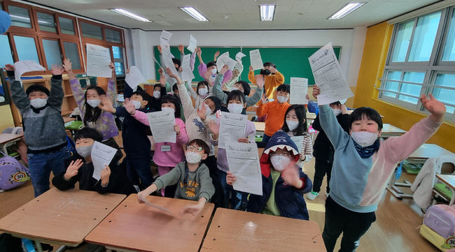 겨울방학이 시작되는 15일 오전 울산 중구 평산초등학교 1학년 교실에서 학생들이 겨울방학 계획서를 들며 즐거워하고 있다.(사진=뉴시스 제공)