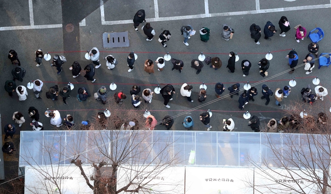 지난 22일 오후 부산진구 보건소 선별진료소를 찾은 시민들이 진단검사를 받기 위해 길게 줄을 선 채 자신의 차례를 기다리고 있다. (사진=뉴시스 제공)