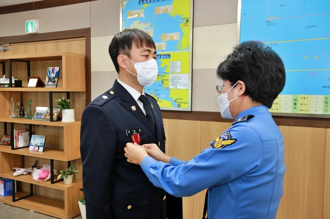 박경순 평택해양경찰서장(오른쪽)이 12월 31일 손호진 경위에게 모범 공무원 표장(標章)을 달아주고 있다