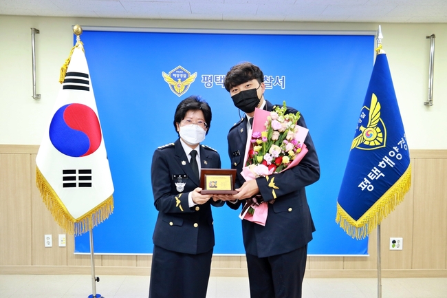 박경순 평택해양경찰서장(왼쪽)이 1월의 자랑스러운 평택해경인으로 선정된 김우영 경위를 격려하고 기념사진을 찍고 있다.