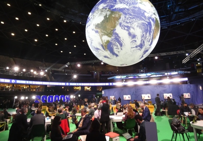 제26차 유엔 기후변화협약 당사국총회(COP26)가 열린 영국 글래스고 스코티쉬이벤트캠퍼스(SEC) 안의 대형 지구 모형 아래에서 참가자들이 회의하고 있다.(사진=뉴시스 제공)