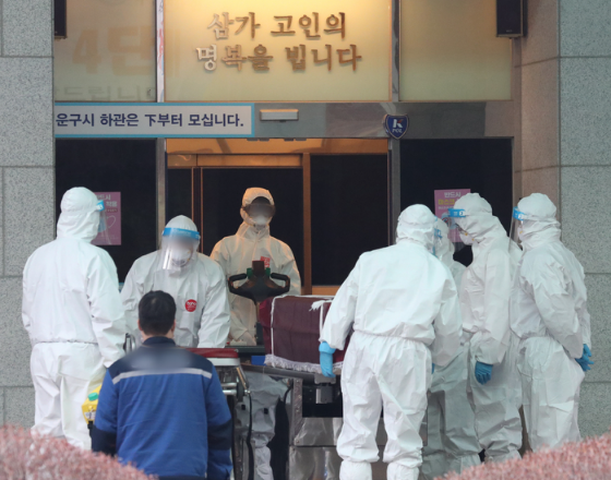 22일 오후 경기도 한 화장장에서 방역 관계자들이 코로나19로 숨진 고인의 관을 화장터로 이송하고 있다. 코로나19 사태가 장기화되면서 수도권의 화장 시설이 포화상태에 이르고 있다.(사진=뉴시스 제공)
