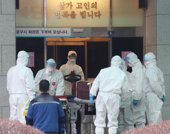 지난해 12월 22일 오후 경기도 한 화장장에서 방역 관계자들이 코로나19로 숨진 고인의 관을 화장터로 이송하고 있다. 코로나19 사태가 장기화되면서 수도권의 화장 시설이 포화상태에 이르고 있다. 