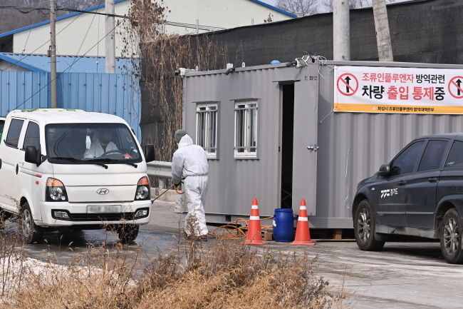 23일 오후 경기도 화성시 한 산란계 농장에서 고병원성 조류인플루엔자(AI) 의심 사례가 발생해 방역 관계자가 통행차량에 소독을 하고 있다. 