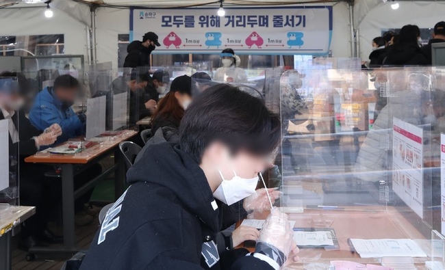 코로나19 신규 확진자가 5만4941명으로 역대 최다를 기록한 12일 오전 서울 송파구 보건소 선별진료소에서 시민들이 신속항원검사를 받고 있다.