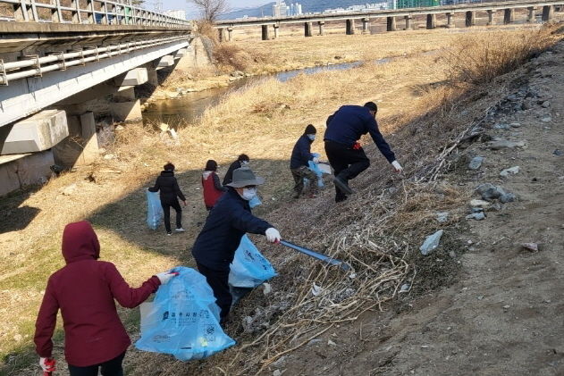 지난 11일 대청소 참여자들이 경주시 현곡면 새한아파트 뒤편 강변에서 쓰레기 수거하고 있다