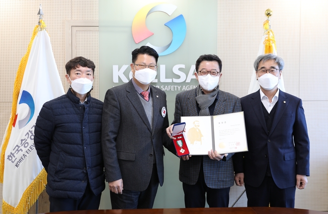 한국승강기안전공단 강희중 교육홍보이사(오른쪽 두 번째)가 16일 대한적십자 경남지사 임군빈 사무처장으로부터 ‘적십자 회원유공장 금장’을 전달받고 관계자들과 기념촬영을 하고 있다.