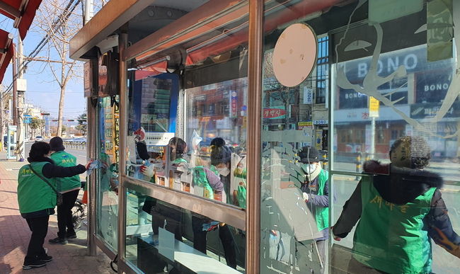 지난 16일 새마을부녀회 회원들이 버스승강장에서 방역소독을 하고 있다