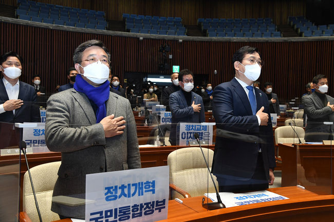 더불어민주당 송영길 당대표(오른쪽)와 윤호중 원내대표(왼쪽)이 27일 서울 여의도 국회에서 열린 의원총회에서 동료의원들과 국민의례를 하고 있다. 당일 의총에서는 국민통합 정치개혁안 등이 논의됐다. / 사진=뉴시스 제공