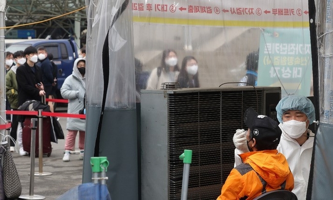 지난 12일 오전 서울 중구 서울역광장 임시선별검사소에서 의료진이 검체를 채취하고 있다. 