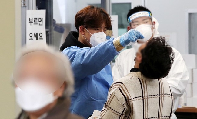0시 기준 코로나19 신규 확진자가 40만7017명 집계된 지난 18일 서울 송파구보건소 선별진료소에서 의료진이 시민들의 검체를 채취하고 있다.