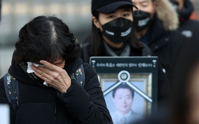  지난 1월22일 오후 서울 중구 청계광장에서 코로나19 백신피해자가족협의회(코백회) 주최로 열린 제10회 백신 희생자 추모식 및 촛불집회에서 한 참석자가 눈물을 훔치고 있다.