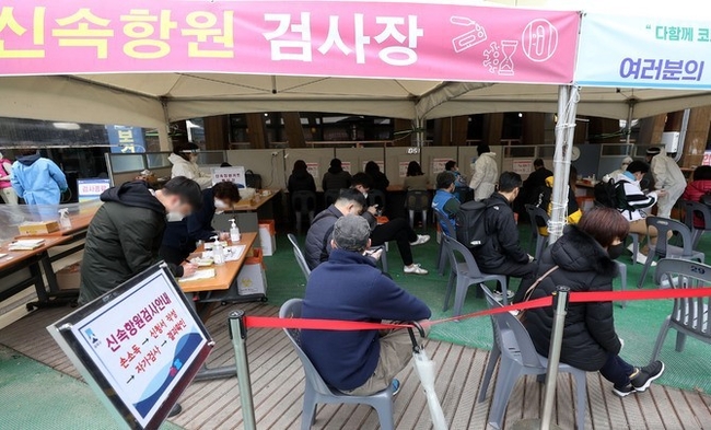 지난 18일 서울 송파구보건소 선별진료소에서 시민들이 신속항원 검사를 마친 뒤 결과를 기다리고 있다.