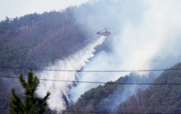 11일 강원 양구 일원에 연무가 걷히자 산불진화헬기가 물을 뿌리며 산불을 진화하고 있다.(사진=산림청 제공) 