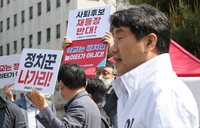 이주호 서울시교육감 예비후보가 지난 6일 서울 종로구 서울시교육청 앞에서 중도보수후보 단일화를 촉구하는 단식에 돌입하며 입장문을 발표하자, 이를 반대하는 사람들이 재단일화를 반대하는 손팻말을 들고 있다.