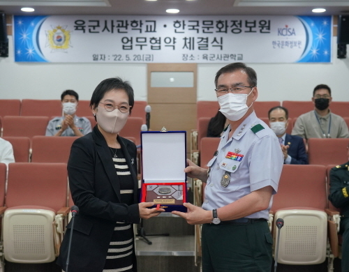 육군사관학교 강창구 학교장(오른쪽)이 한국문화정보원 홍희경 원장(왼쪽)에게 기념품(화랑 8경 액자)를 증정하고 있다.