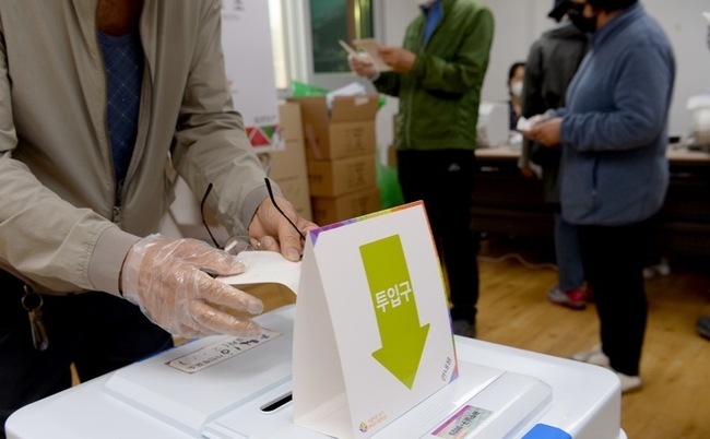 8회 6·1전국동시지방선거 사전투표 첫날인 27일 오전 광주 남구 주월동 통합 거점 경로당 투표소에서 시민이 투표용지를 넣고 있다(사진=뉴시스 제공)