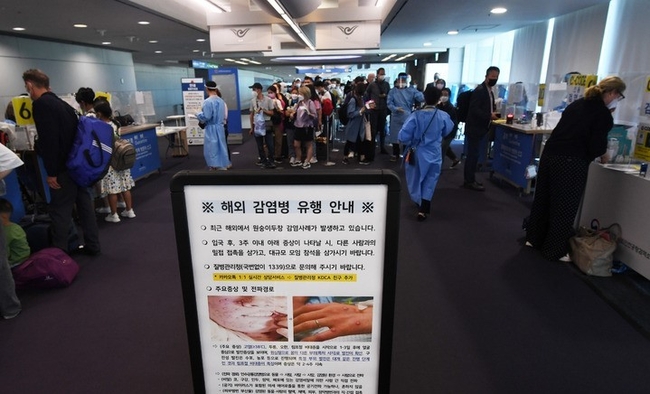 최근 해외에서 원숭이 두창 감염사례가 발생하고 있는 27일 오전 인천국제공항 제1여객터미널 입국장에서 독일 프랑크푸르트와 우즈베키스탄발 탑승객들이 검역을 받기 위해 대기하고 있는 가운데 원숭이 두창 안내문이 게시되어 있다. (공동취재사진)