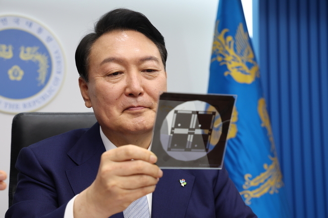 윤석열 대통령이 7일 서울 용산 대통령실 청사 영상회의실에서 열린 국무회의에서 반도체 포토마스크를 바라보고 있다. (사진=대통령실 제공)