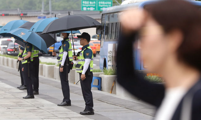 사진=뉴시스 제공(서울 종로구 광화문 광장에서 경찰들이 햇볕을 피하기 위해 우산을 쓰고 있다)
