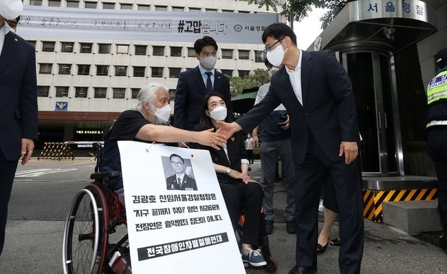 박경석 전국장애인차별철폐연대(전장연) 대표와 최혜영 더불어민주당 의원이 27일 오전 서울 종로구 서울경찰청 앞에서 김광호 서울경찰청장의 '지구 끝까지 찾아가 사법처리하겠다' 발언에 대한 면담 요청서 전달을 위해 서울경찰청 정보국장과 인사하고 있다(사진=뉴시스 제공)