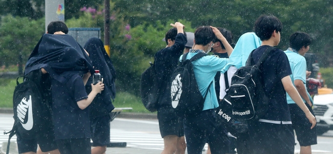 소나기가 내린 7일 오후 서울 도심에서 우산을 준비하지 못한 학생들이 빠른 발걸음으로 이동하고 있다. (사진=뉴시스 제공)