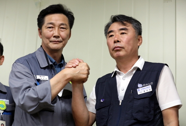 대우조선해양 하청 노사협상이 파업 51일 만에 타결된 22일 오후 경남 거제시 대우조선해양 옥포조선소에서 협력사 대표 권수오(왼쪽) 녹산기업 대표와 홍지욱 금속노조 부위원장이 악수를 하고 있다. (사진=뉴시스 제공)