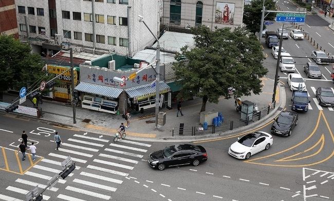 횡단보도 앞 일시정지 의무를 확대하는 등 보행자 보호의무가 강화된 도로교통법 시행 첫날인 12일 오후 서울 시내 한 횡단보도에서 우회전하는 차량이 보행자의 횡단을 기다리고 있다.