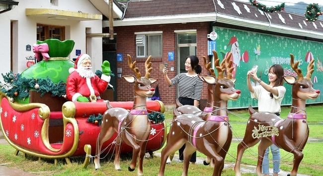 여름 산타마을 개장을 하루 앞둔 22일 오후 경북 봉화군 분천역 산타마을을 찾은 시민들이 산타와 함께 기념촬영을 하고 있다. (사진=뉴시스)