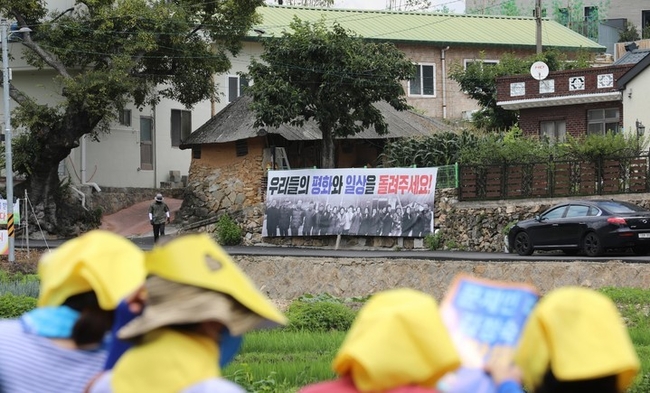 17일 오후 경남 양산시 하북면 평산마을 문재인 전 대통령 사저 앞에서 진보 단체 집회자들이 문 전 대통령 내외를 지지하는 문구가 적힌 피켓을 들어보이고 있다. (사진=뉴시스)
