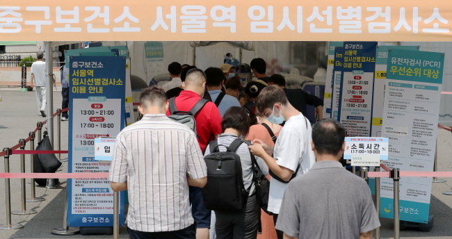 코로나19 신규 확진자가 10만1140명으로 집계된 26일 오후 서울 중구 서울역광장에 마련된 임시선별검사소에서 시민들이 검사를 받기 위해 대기하고 있다. 