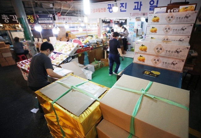추석을 앞둔 지난 5일 서울 종로구 광장시장에서 시장 상인이 과일 택배 박스를 옮기고 있다. 