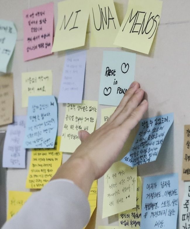  지난 14일 서울교통공사 역무원 스토킹 살인사건이 발생한 서울 지하철 2호선 신당역 여자화장실 앞에 마련된 추모공간에서 18일 오전 한 시민이 추모하고 있다. 