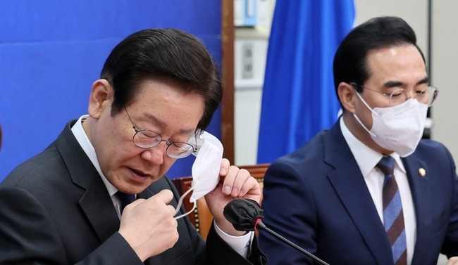 이재명 더불어민주당 대표가 지난 14일 서울 여의도 국회에서 열린 민주당 최고위원회의에 참석해 발언을 위해 마스크를 벗고 있다. (공동취재사진)