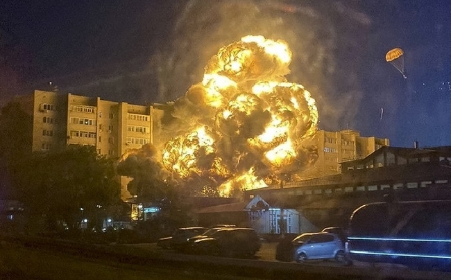 17일(현지시간) 러시아 예이스크의 한 아파트에 러시아군의 SU-34 전폭기 한 대가 추락해 화염이 솟구치는 가운데 조종사 한 명이 낙하산으로 탈출하고 있다. 사고 당시 전폭기 조종사 2명은 탈출했으나 연료가 폭발하면서 화재가 발생해 주민 최소 4명이 숨지고 6명이 실종됐으며 중상자 8명 포함 25명이 다친 것으로 알려졌다.(사진=뉴시스 제공)