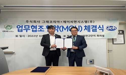 김광환(오른쪽) ㈜그래코리아 대표와 송창재 제이씨현시스템(주) 영업대표가 비산먼지 방지 사업확대를 위한 협약식을 갖은 후 기념촬영을 하고 있다