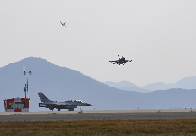 지난달 31일 한미 공군의 대규모 연합공중훈련인 비질런트 스톰(Vigilant Storm) 훈련에 참가한 우리 공군 KF-16 전투기가 군산기지에서 이륙을 위해 활주로 진입을 기다리고 있는 가운데, 그 위로 미군 F-16 전투기가 착륙을 하고 있다. (사진=공군 제공)