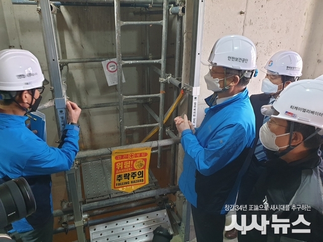 승강기 설치 추락사고, 이제 그만!(안전보건공단 안종주 이사장(가운데)이 건설현장에 처음 적용된 승강기 설치 전용 작업대를 살펴보고 있다.)